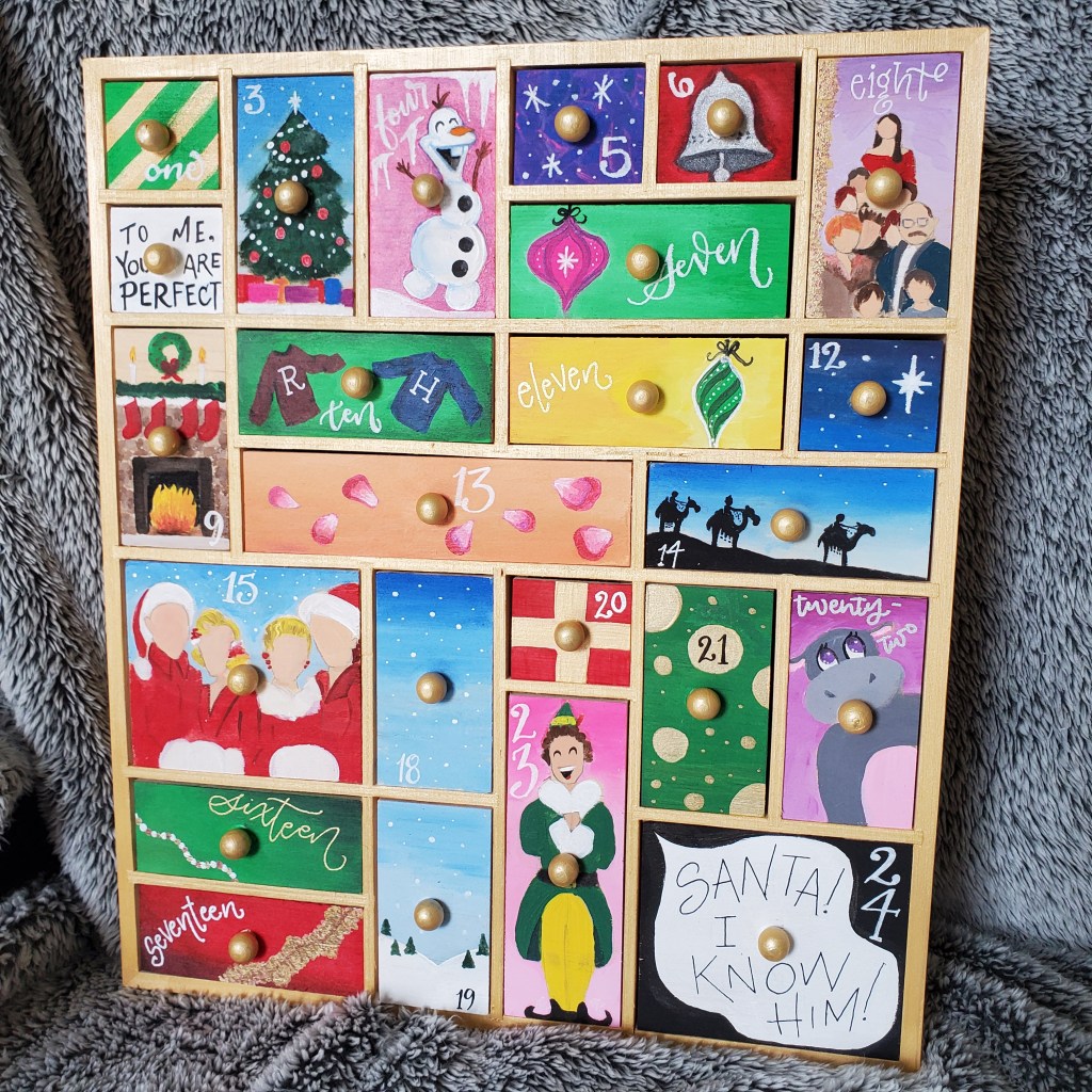 Custom handpainted wooden advent calendar with movie references from Love Actually, Frozen, White Christmas, and Elf